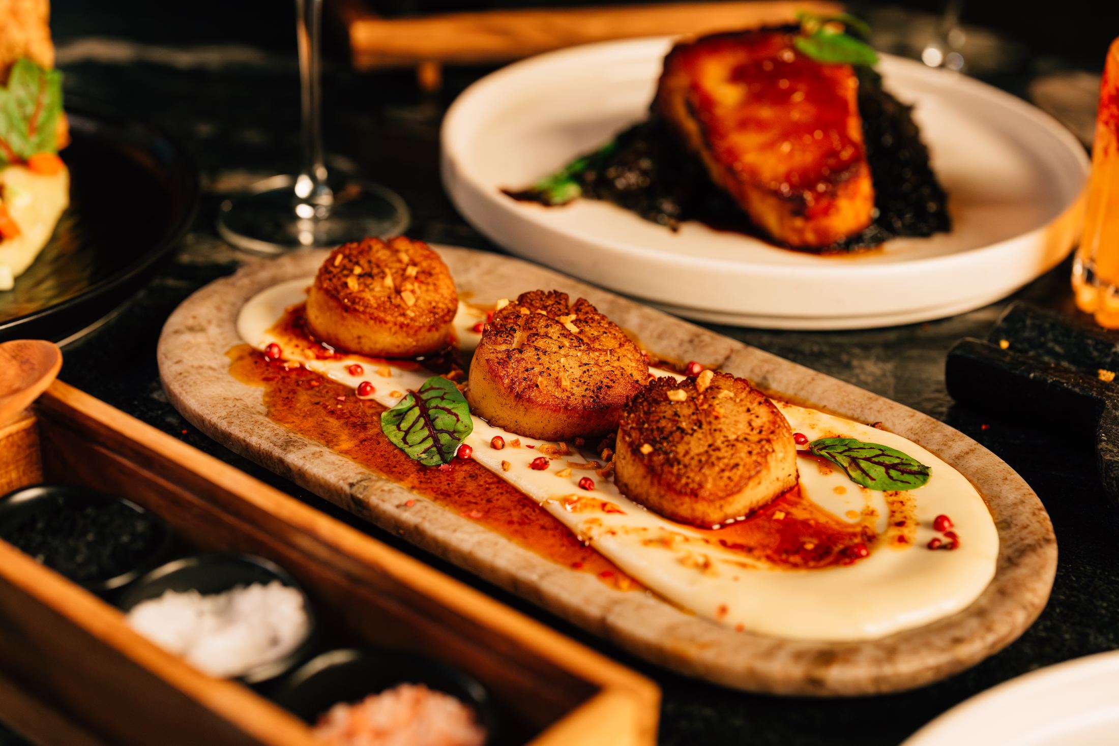 Seared scallops and lacquered fish plated together